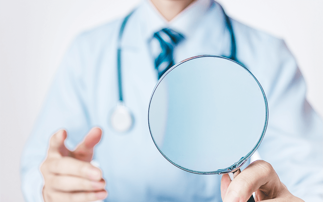 Photo of a doctor holding a magnifying glass. Photo d'un médecin tenant une loupe.