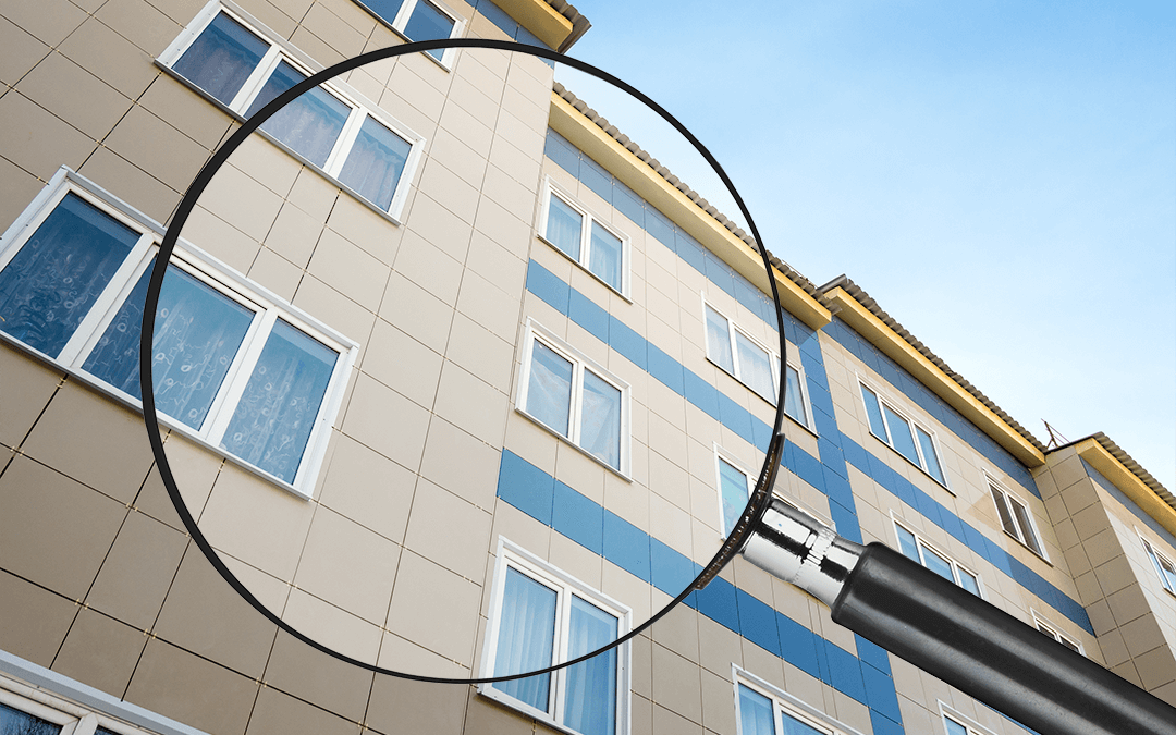 Photo of a building with a magnifying glass in the forefront. Une photo d'une édifice avec une loupe en avant.