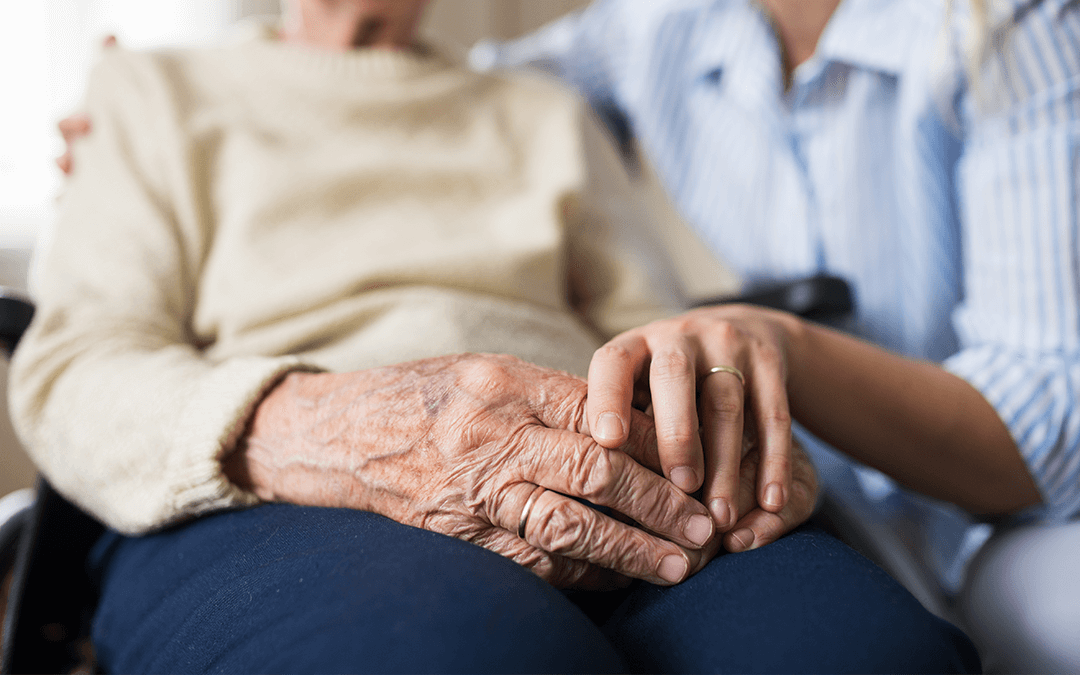 Photo of a nurse holding an elderly woman's hand. Photo d'une infirmière tenant la main d'une femme âgée.