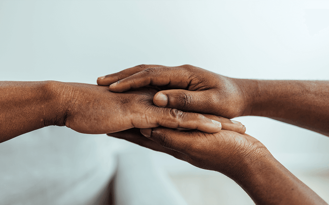 Photo of a nurse holding a senior man's hands in comfort. Photo d'une infirmière tenant confortablement les mains d'un homme âgé.